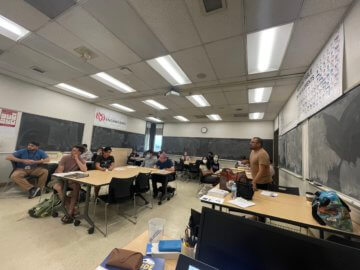 Man giving classroom presentation to a group of students. 