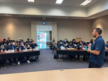 Presenter speaking to a classroom as they eat lunch. 